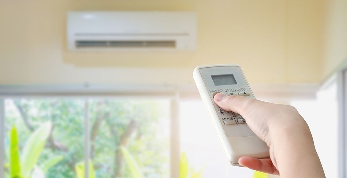 Hand mit Fernbedienung für Klimaanlage in Niederösterreich